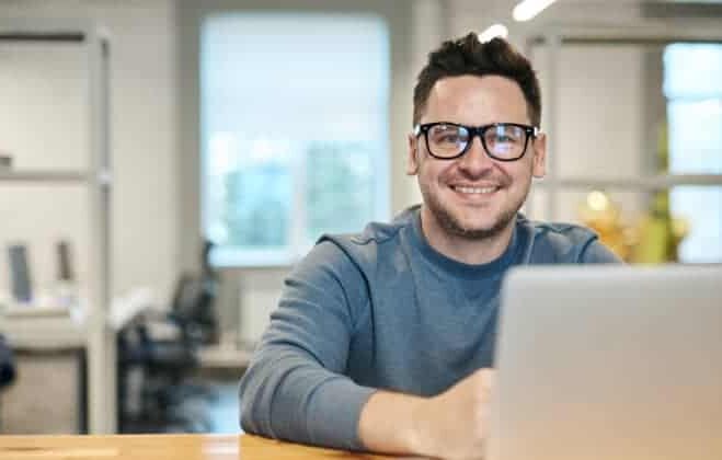 Man sitting at a table filling out forms on a computer